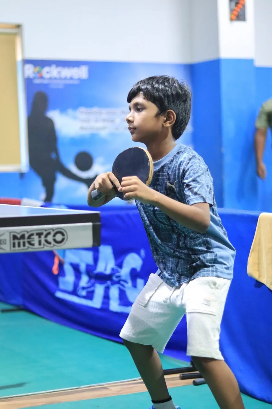 Young athlete in forehand ready stance at the table
